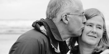 Older man leaning over to kiss woman Photo by Esther Ann on Unsplash