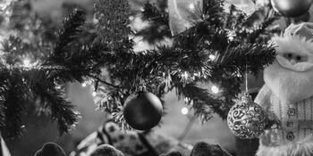 Two sets stockinged feet under a Christmas tree Photo by Arthur Brognoli Pexels