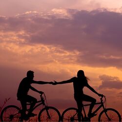 Couple riding bikes holding hand out Photo by Everton Vila on Unsplash