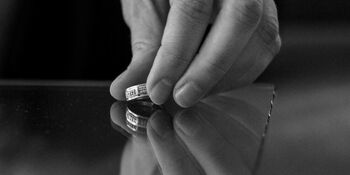 Womans hand placing wedding ring on table divorce Photo by cotonbro pexels