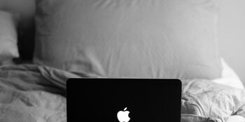 Laptop on bed with pillows by Justin Morgan on Unsplash