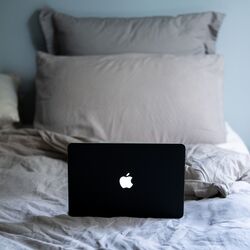 Laptop on bed with pillows by Justin Morgan on Unsplash
