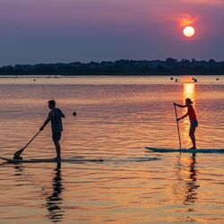 Couple on a paddle board date by Nick Fewings