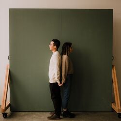 Couple standing back to back by Blake Carpenter on Unsplash