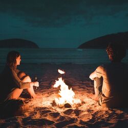 couple talking next to a fire by manuel meurisse on unsplash