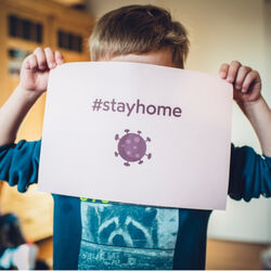 Boy holding stay at home sign Photo by Markus Spiske on Unsplash